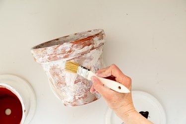 applying plaster to DIY aged terra cotta pots