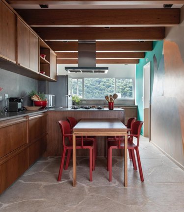 Kitchen with dark wood cabinet, gray stone floor.