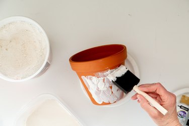 applying plaster to DIY aged terra cotta pots