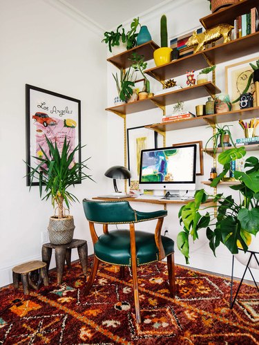 Home office with green chair and maroon patterned rug