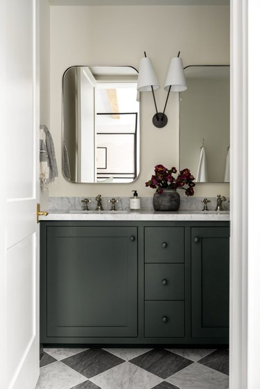 Basement double vanity with mirrors and green cabinets
