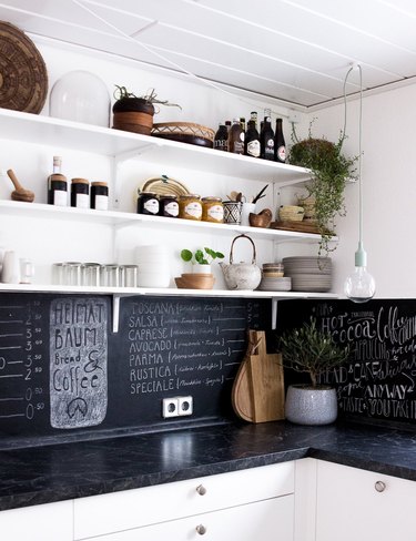 black and white kitchen with chalkboard backsplash