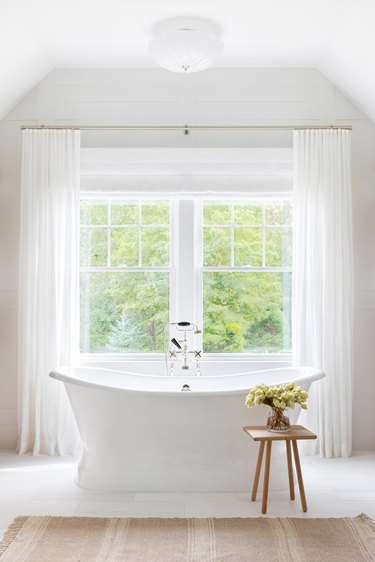 white bathroom with flush-mount light fixture above tub