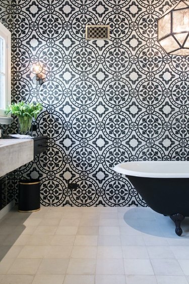 black and white bathroom with cement wall tile and zellige floor tile
