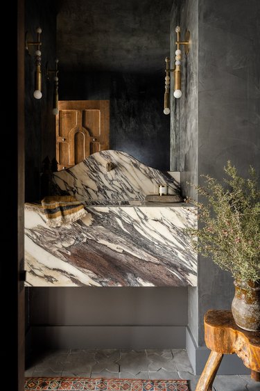 moody dark gray bathroom with beaded wall sconces