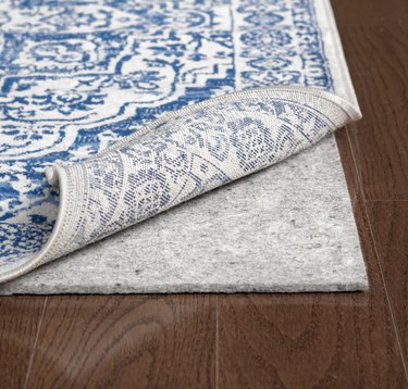 rug pad placed underneath a blue and white rug