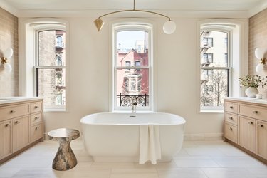 mobile-style chandelier hanging over tub in bathroom