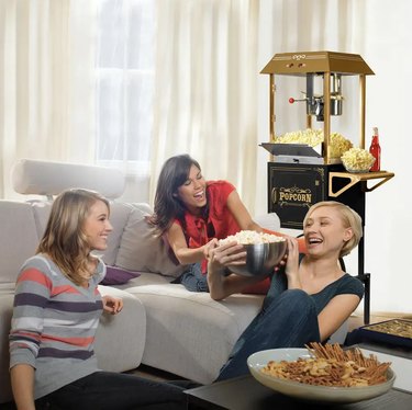popcorn machine in a media room with three women sharing a bowl of popcorn