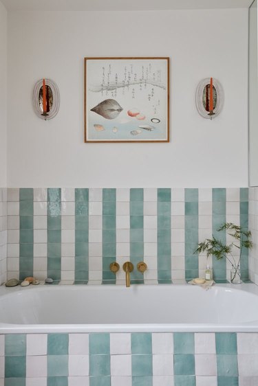 bathroom with candle sconces above the tub