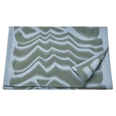 A towel featuring a light blue and sage green abstract pattern.