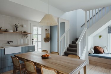 open kitchen with blue cabinets and dining table with chairs