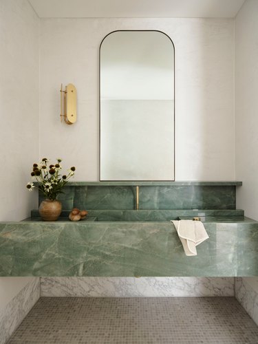 modern bathroom with streamlined brass sconce