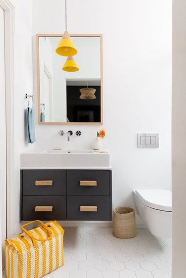 small bathroom with yellow pendant light hanging over vanity cabinet