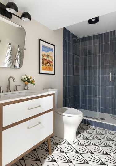 Basement bathroom with blue wall tiles and graphic floor tiles