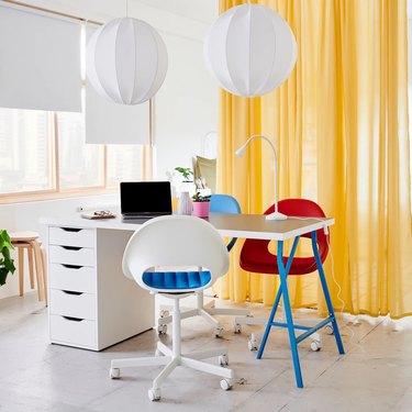 white and yellow home office with yellow curtain divider, red desk chair