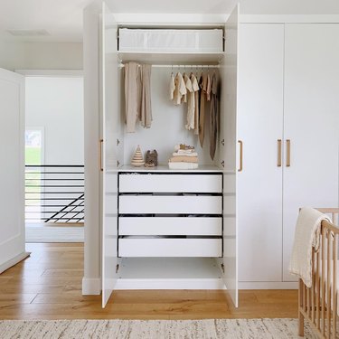 white nursery closet with brass accents