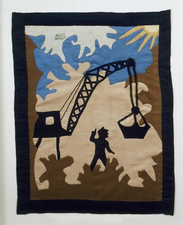 quilt with pattern of a worker and crane