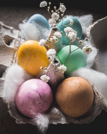 naturally dyed easter eggs in carton with baby's breath