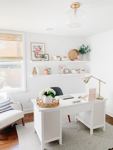 white modern office with white floating shelves and pastel decorative pieces