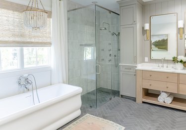 transitional farmhouse bathroom idea with beaded chandelier and freestanding tub