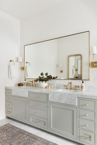 modern farmhouse bathroom idea with white marble countertop and faux apron front, blue green cabinetry and gold accents