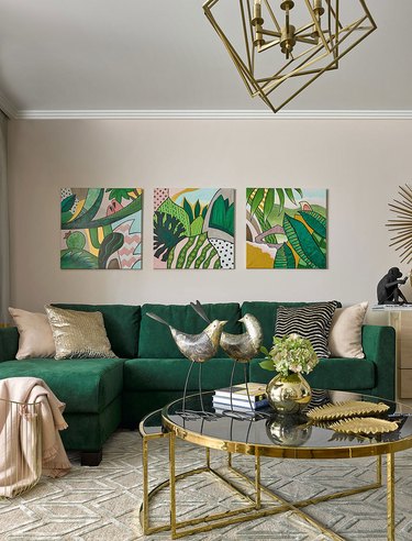 Living room with neutral walls and emerald green sofa.