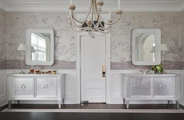 Bedroom with patterned wallpaper and silver cabinets.