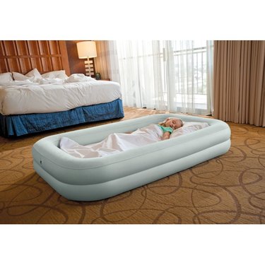 Child sleeping on hotel floor in Intex Kids Travel Bed Set