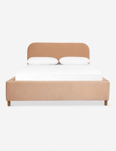 platform bed in neutral color with white sheets