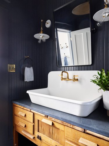 dark and moody industrial farmhouse bathroom idea with vintage touches and farmhouse sink