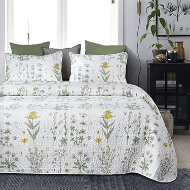 bed covered with white quilt with yellow flowers