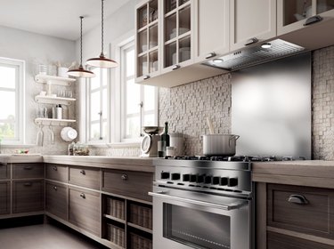 Kitchen with wood cabinets, tile backsplash, stainless backsplash, stainless range.