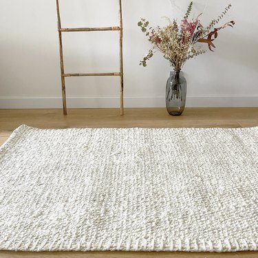 white braided rug on a light-wood floor