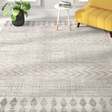 Zipcode Design Herrod rug in gray and white in a living room with a yellow couch