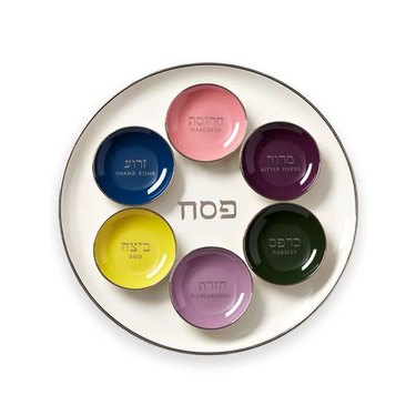 A Seder plate with mini colorful, labeled plates on it.