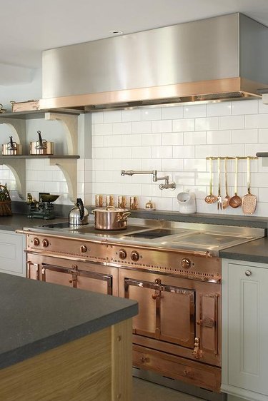 mixed metal kitchen with rose gold stove and stainless hood