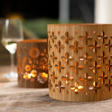 A wood candle holder with decorative cutouts so candlelight shines through.