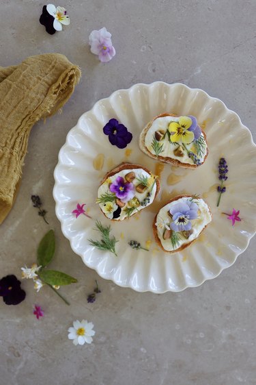 Whipped feta dip on crostini garnished with edible flowers