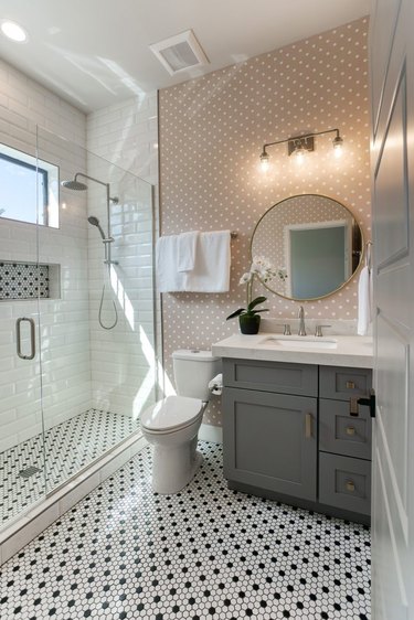 bathroom idea with pink polka dot wallpaper and black and white floor tile