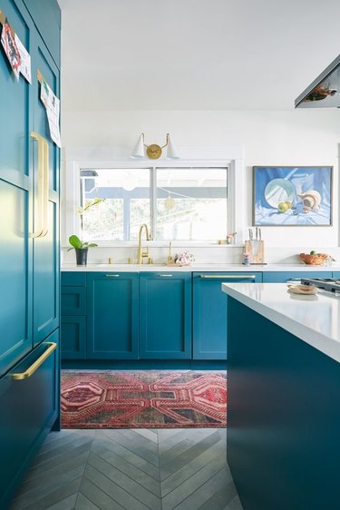 teal kitchen cabinets with gray flooring
