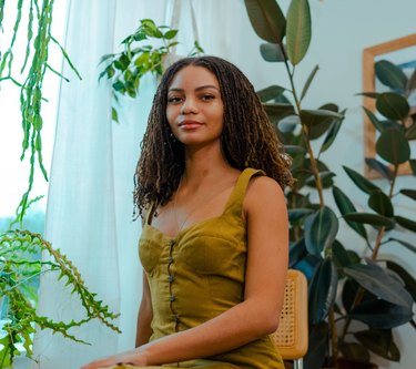 leah thomas sitting on chair in room with plants