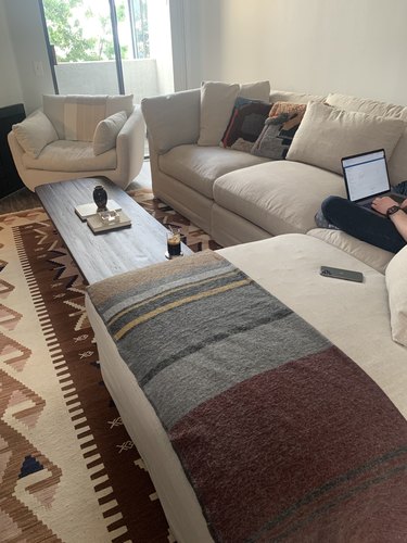 sofa in living room with striped blanket and patterned rug