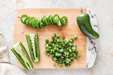 Diced jalapeños on a wooden cutting board