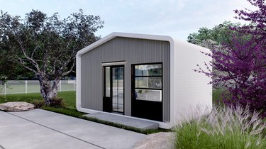 A rendering of a 3d gray printed home with glass doors with black trim on a green space