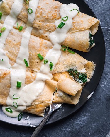 The Curious Chickpea Savory Crepes with Almond Cheese, Sautéed Spinach, and Vegan Hollandaise