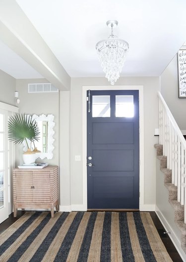 Entryway with pewter walls and a navy blue door.