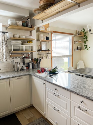 Summar Saad kitchen with white cabinets open shelving and granite countertops