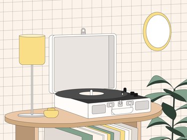 An illustration of a record player on a table with a small lamp and records on the shelf below it.