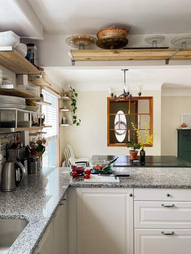 Summar Saad kitchen with white cabinets open shelving and granite countertops