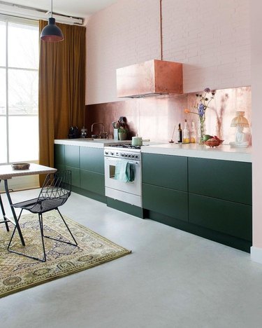 Pink and green modern kitchen with copper hood.